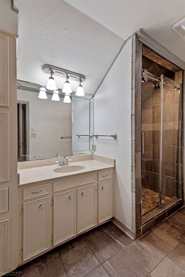 bathroom featuring vanity, a textured ceiling, tile patterned flooring, and a shower with door