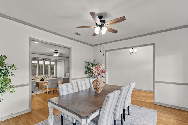 dining area with light hardwood / wood-style floors, ornamental molding, and ceiling fan