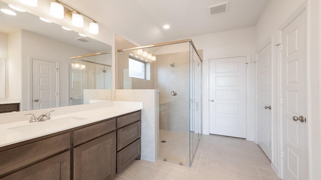 bathroom featuring an enclosed shower, vanity, and tile patterned floors