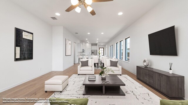 unfurnished living room featuring ceiling fan and light hardwood / wood-style flooring