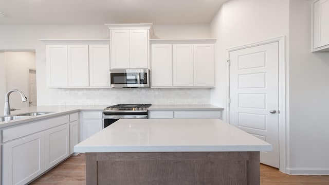 kitchen featuring sink, stainless steel appliances, white cabinets, and backsplash