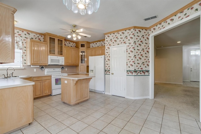 kitchen with a kitchen island, sink, crown molding, light colored carpet, and white appliances