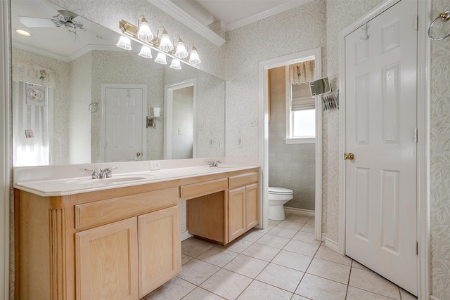 bathroom with toilet, ceiling fan, vanity, crown molding, and tile patterned flooring