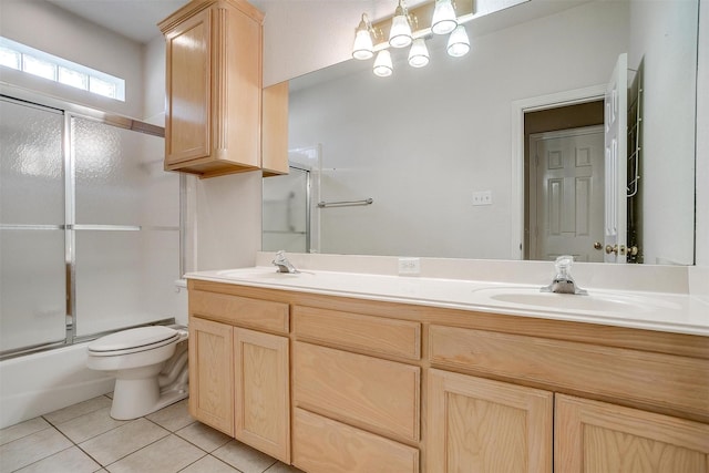 full bathroom with tile patterned flooring, vanity, bath / shower combo with glass door, and toilet