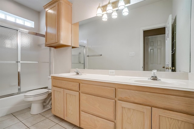 full bathroom with vanity, bath / shower combo with glass door, toilet, and tile patterned flooring