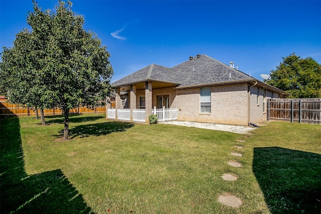 back of property with a patio and a lawn