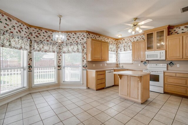 kitchen featuring light brown cabinets, sink, a center island, white appliances, and ceiling fan