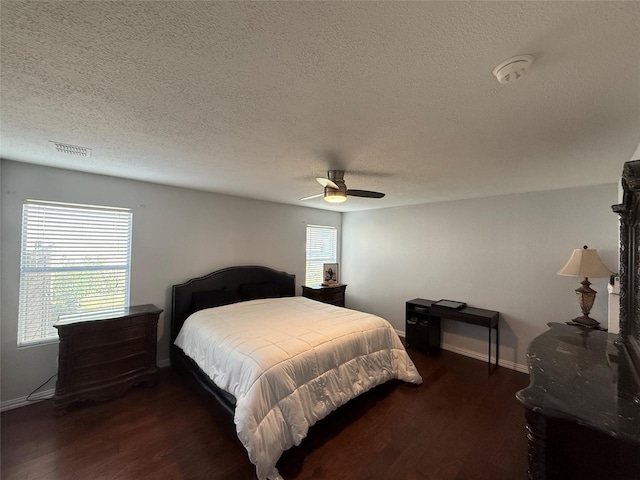 bedroom featuring a textured ceiling, dark hardwood / wood-style flooring, and ceiling fan