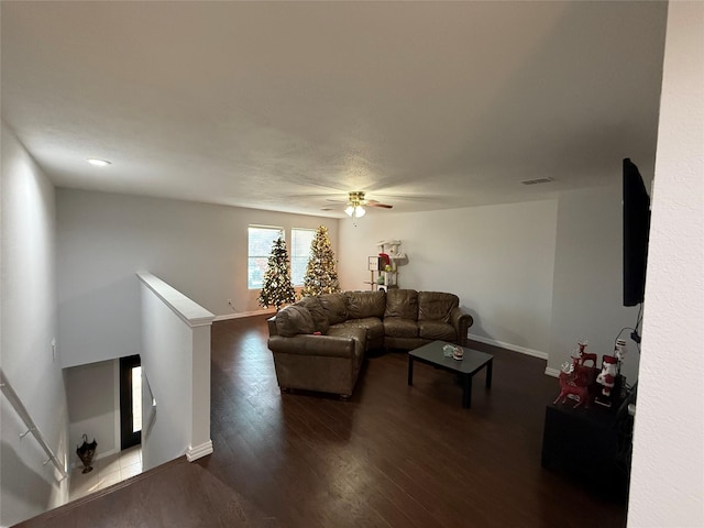 living room with ceiling fan and dark wood-type flooring