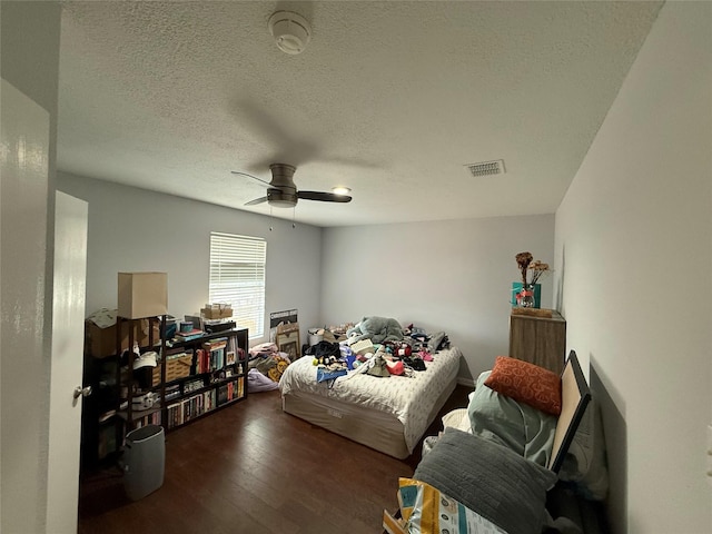 bedroom featuring a textured ceiling, dark hardwood / wood-style floors, and ceiling fan