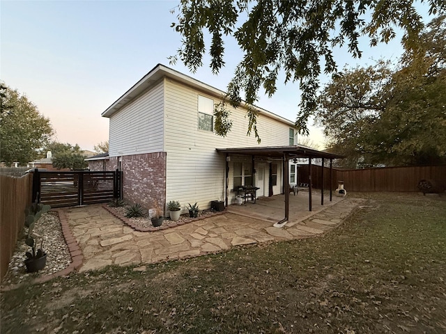 back house at dusk with a patio