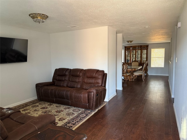 living room featuring a textured ceiling and dark hardwood / wood-style floors