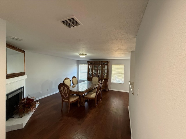 dining area featuring a textured ceiling and dark wood-type flooring