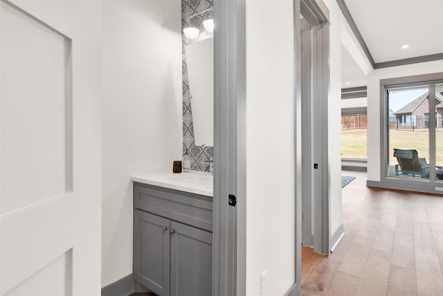 bathroom with vanity, ornamental molding, and hardwood / wood-style flooring