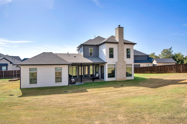 rear view of property featuring a yard and a patio