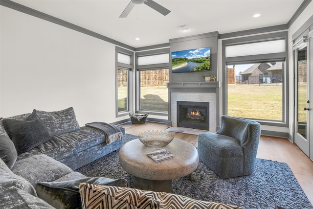 living room with ornamental molding, hardwood / wood-style floors, a healthy amount of sunlight, and ceiling fan