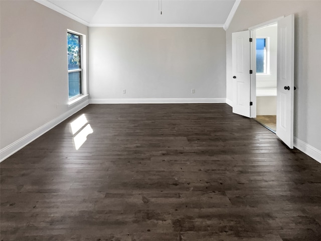 empty room featuring ornamental molding, vaulted ceiling, and dark hardwood / wood-style floors