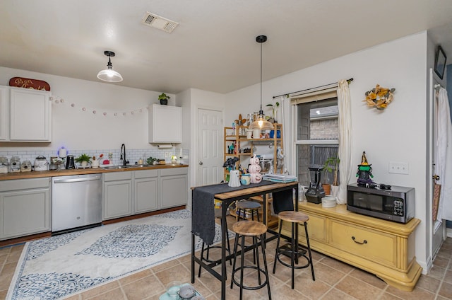 kitchen with white cabinetry, appliances with stainless steel finishes, pendant lighting, and decorative backsplash