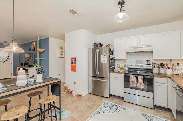 kitchen with appliances with stainless steel finishes, backsplash, white cabinetry, decorative light fixtures, and wooden counters