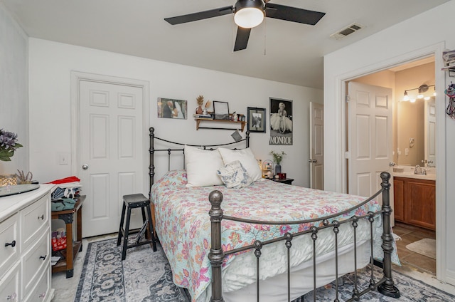 bedroom with ceiling fan, sink, and ensuite bath