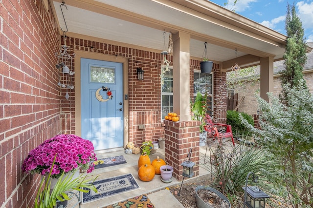 view of exterior entry featuring covered porch