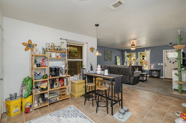 carpeted dining room featuring ceiling fan and a wealth of natural light