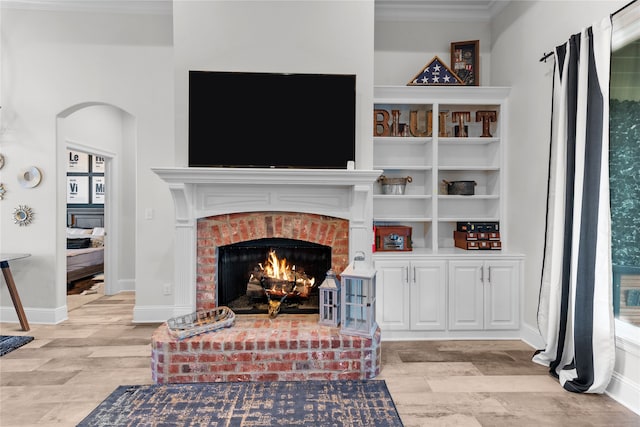 living room featuring crown molding and a brick fireplace