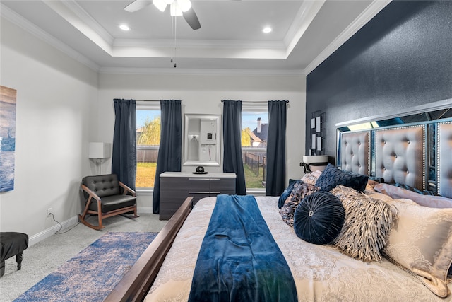 bedroom featuring ornamental molding, a raised ceiling, light colored carpet, and ceiling fan