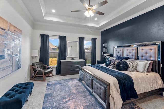 carpeted bedroom with ornamental molding, a raised ceiling, and ceiling fan