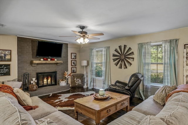 living room with dark wood-type flooring, ceiling fan, and a fireplace