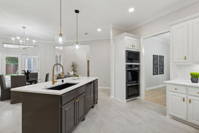 kitchen featuring appliances with stainless steel finishes, white cabinets, sink, and decorative light fixtures