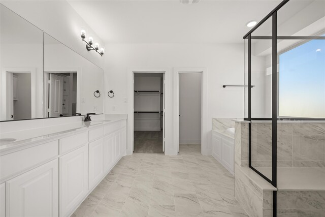 bathroom with vanity and shower with separate bathtub