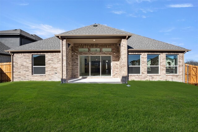 rear view of house with a yard and a patio