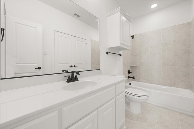 full bathroom with toilet, tile patterned flooring, vanity, and tiled shower / bath