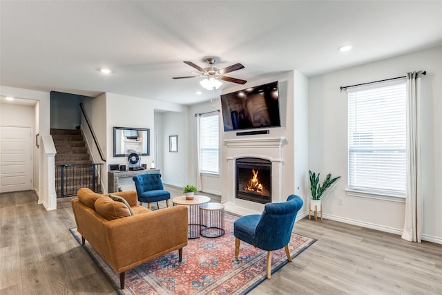 2608 Hale Rd, Celina, TX 75009 - living area featuring a warm lit fireplace, light wood-style flooring, stairway, a ceiling fan, and recessed lighting
