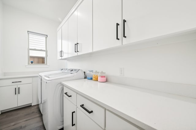 washroom featuring washer and clothes dryer, dark hardwood / wood-style floors, and cabinets