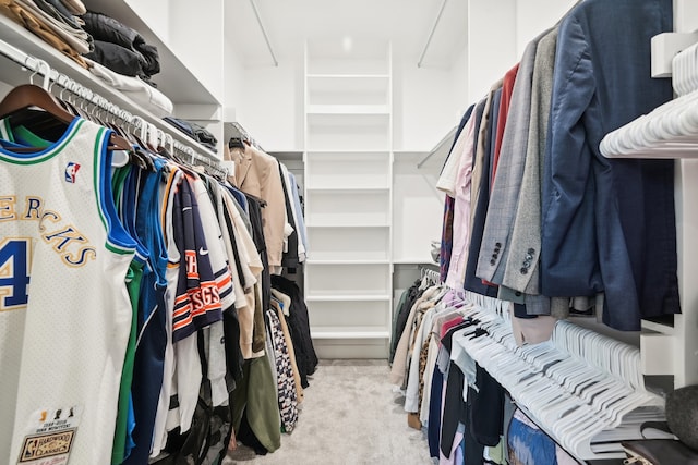 walk in closet with light colored carpet