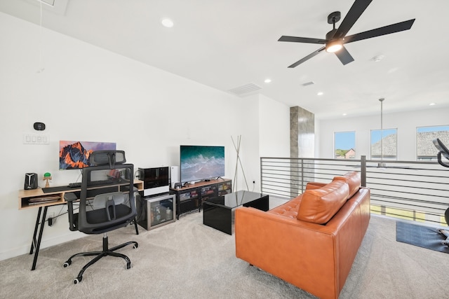 carpeted home office featuring ceiling fan