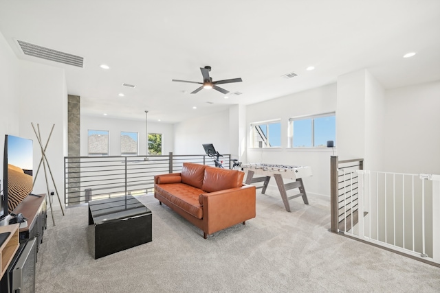 living room featuring ceiling fan, plenty of natural light, and light colored carpet