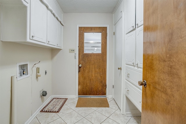 laundry area featuring cabinets, washer hookup, light tile patterned floors, a textured ceiling, and electric dryer hookup