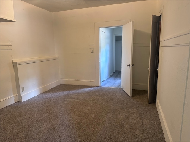 spare room with dark carpet