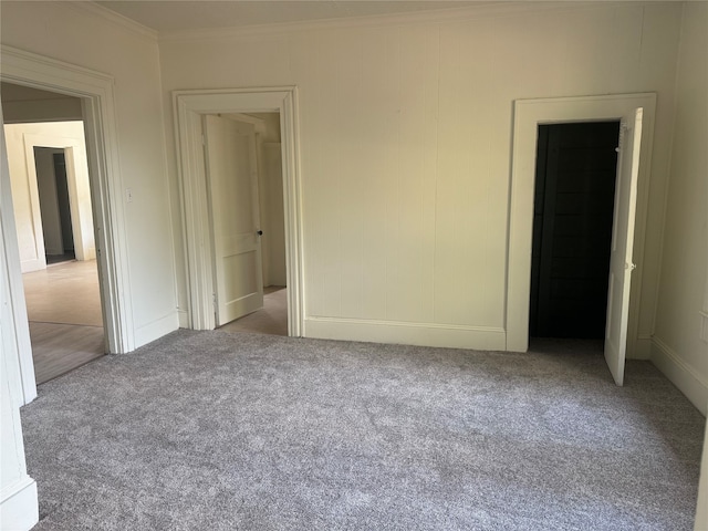 unfurnished room featuring ornamental molding and carpet