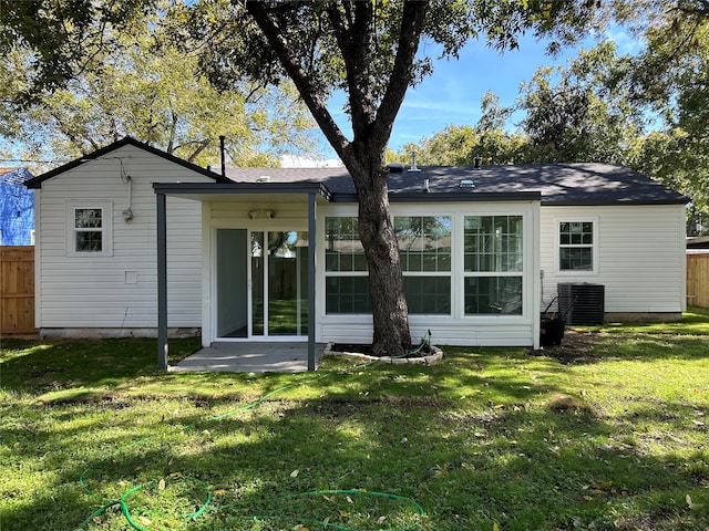 rear view of house featuring central AC and a yard