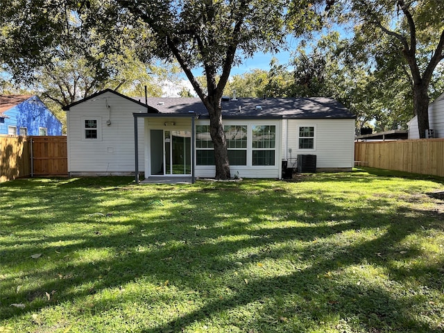 rear view of house with a lawn and cooling unit