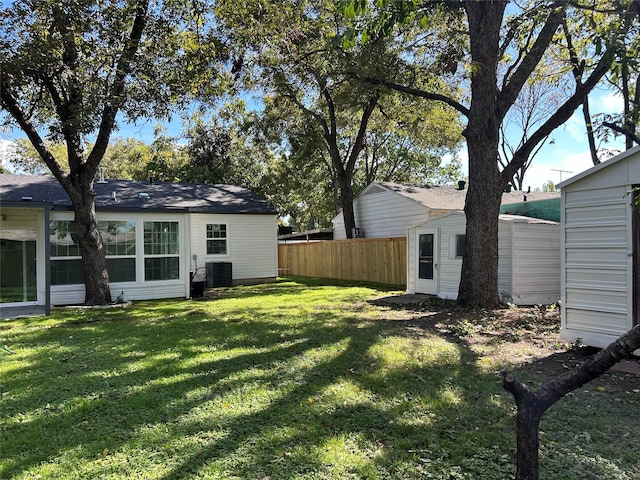 115 Whitham St, Irving, TX 75060 - view of yard with an outdoor structure, central AC unit, fence, and a storage shed