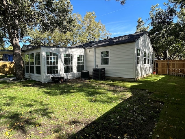 back of house featuring a yard and central AC