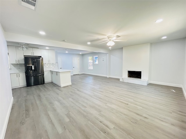 unfurnished living room featuring light wood-type flooring and ceiling fan