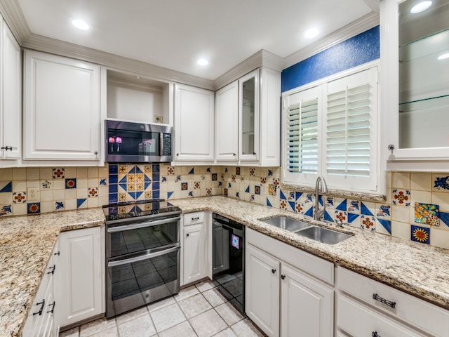 kitchen with tasteful backsplash, sink, stainless steel appliances, white cabinets, and light stone counters