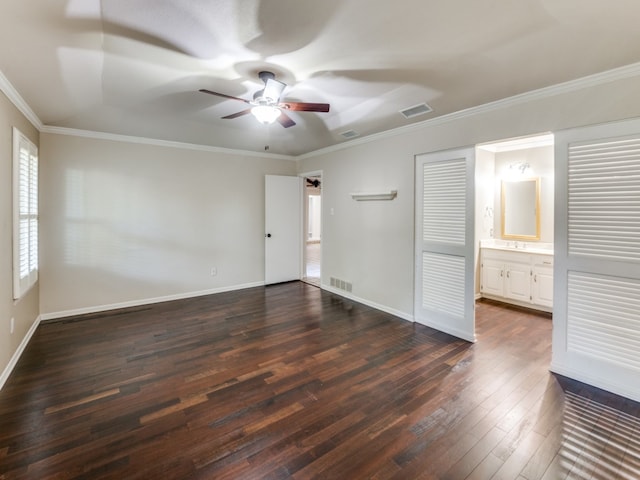 unfurnished bedroom with ceiling fan, dark hardwood / wood-style floors, ornamental molding, and ensuite bath