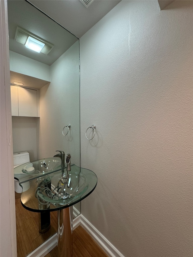 bathroom with toilet and hardwood / wood-style floors